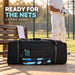 CA Pro 10000 black wheeled cricket kit bag beside a cricket practice net