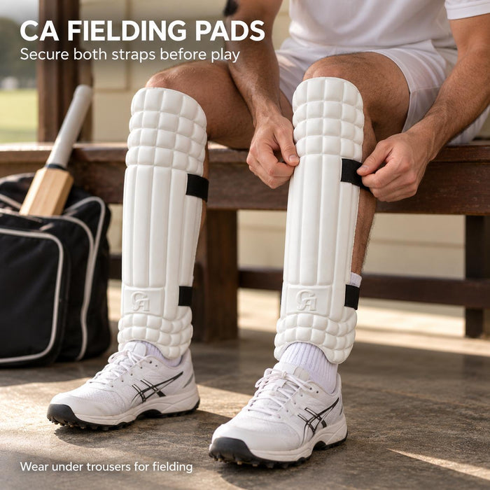 Cricketer fitting white CA Fielding Pads with two black straps before wearing trousers