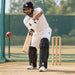 CA Gold 20K black cricket batting pads worn by a batter playing a shot in training nets