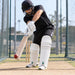 CA Pro 10K white batting leg guards worn by a cricketer playing a defensive shot in practice nets