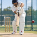 CA Pro 8K white cricket batting leg guards with red CA PRO logo worn by batter playing a defensive shot in nets