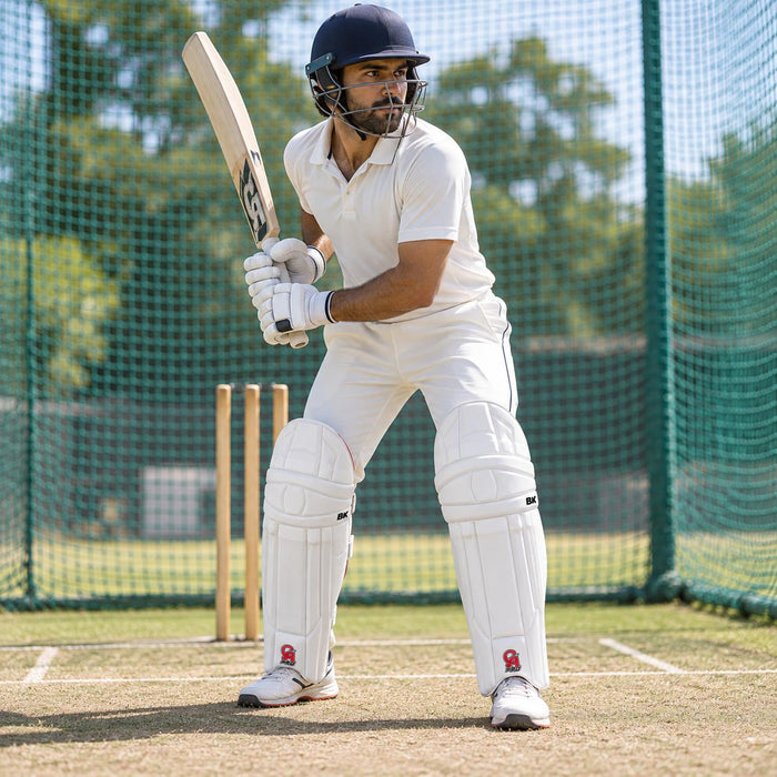 CA Pro 8K white batting pads with red CA PRO branding worn by cricketer in ready batting stance