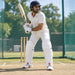 CA Pro 8K white batting pads with red CA PRO branding worn by cricketer in ready batting stance