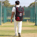 Cricketer carrying the black and red SG Dragon Ace kit bag with both shoulder straps