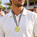 Cricket Arabia gold-colour cricket medal with striped ribbon worn at an award presentation