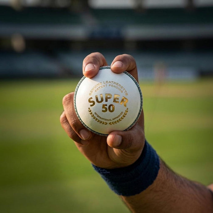 SG Super 50 white cricket ball held in hand with wrist and forearm visible