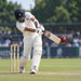 CA red cricket ball in a batting scene on a cricket ground