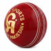 Angled red CA cricket ball showing white seam stitching
