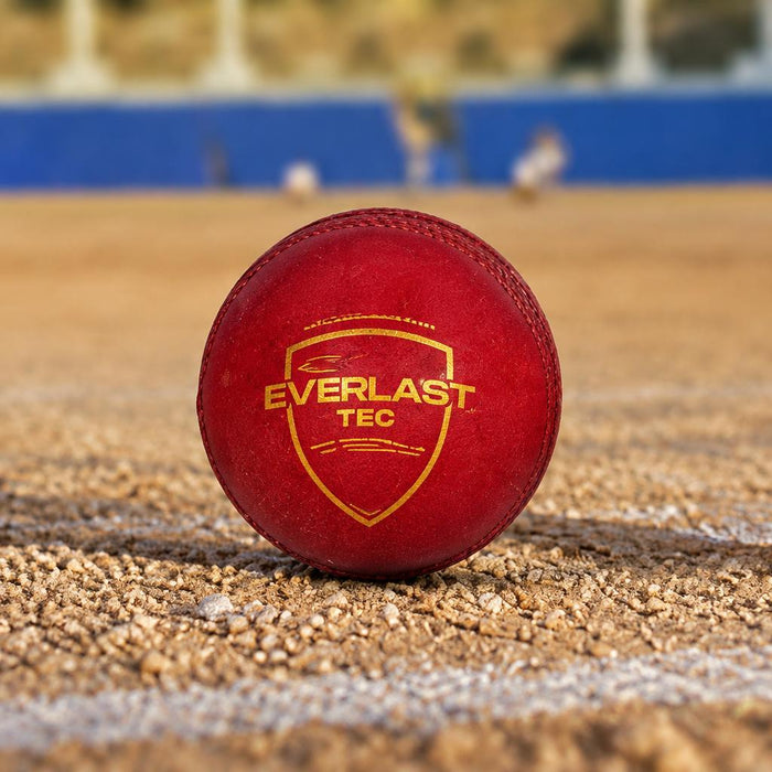 Red SG Everlast Tec ball on a dusty cricket ground