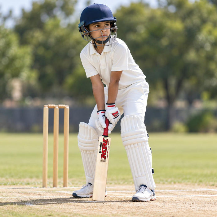 MRF Genius Grace Edition English Willow Cricket Bat - Junior Size 6 shown held in a batting guard with full cricket protective equipment