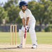 MRF Genius Grace Edition English Willow Cricket Bat - Junior Size 6 shown held in a batting guard with full cricket protective equipment