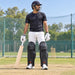 MRF Power 2.0 black batting leg guards worn by a mens cricketer on a practice pitch