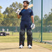 MRF Power 2.0 black batting leg guards worn by a mens cricketer beside the practice nets