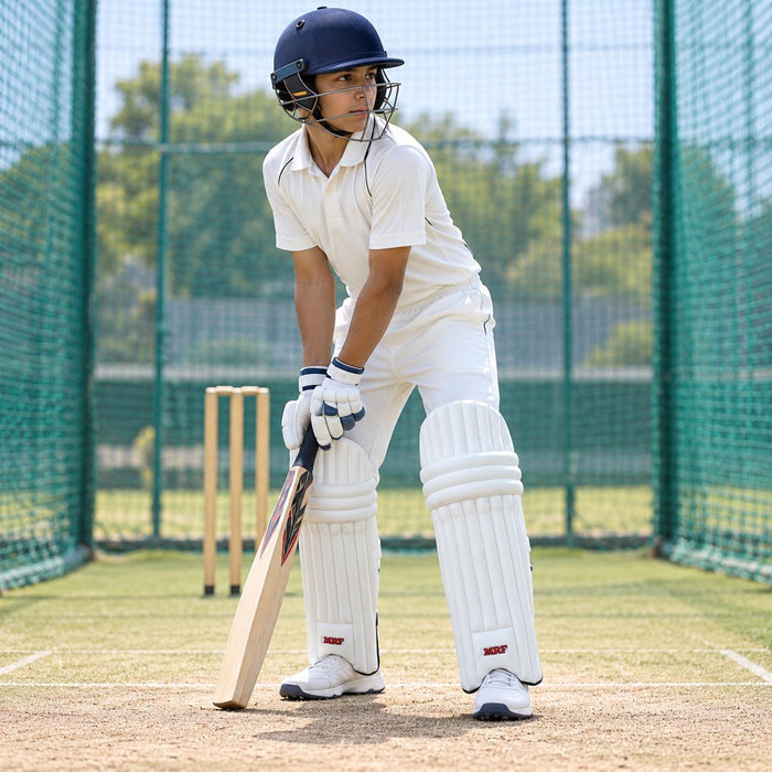 Youth cricketer wearing white MRF Prodigy batting leg guards in a batting stance