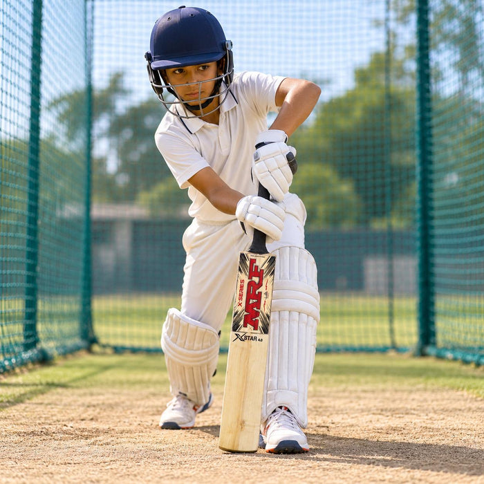 Cricketer using the MRF Xstar 4.0 English Willow Junior Cricket Bat - Size 6 during practice in cricket nets