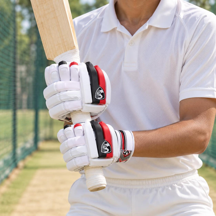 SG Blazelite white red and black cricket batting gloves worn while gripping a bat at practice nets