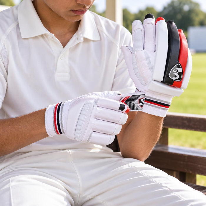 Junior cricketer preparing SG Blazelite batting gloves before practice