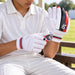 Junior cricketer preparing SG Blazelite batting gloves before practice