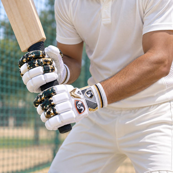SG HP Lite white gold and camouflage batting gloves worn while gripping a bat at cricket nets