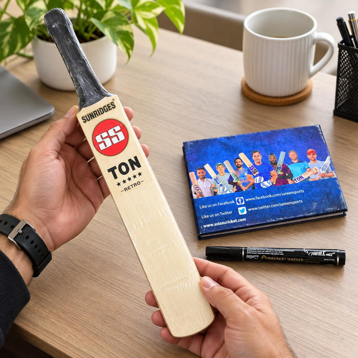 SS unsigned miniature autograph bat held beside the included autograph book and permanent marker