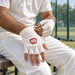 Adult cricketer adjusting the elasticated cuff of SS Club Plus fingerless batting inner gloves before practice