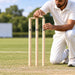 Cricketer placing the second bail on an SG Tournament wooden wicket